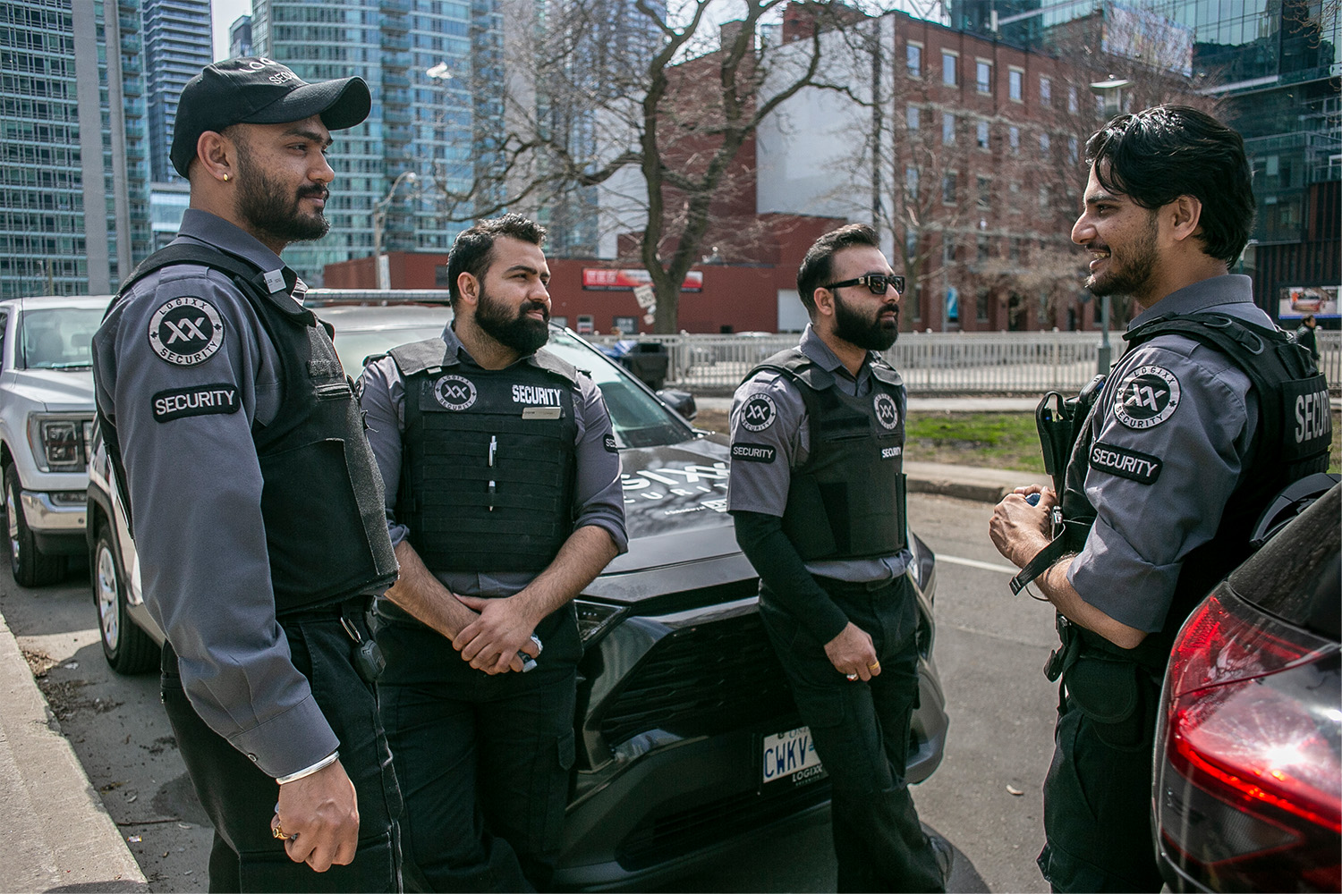 Security guards stand by their vehicle, parked next to Clarence Square Park.