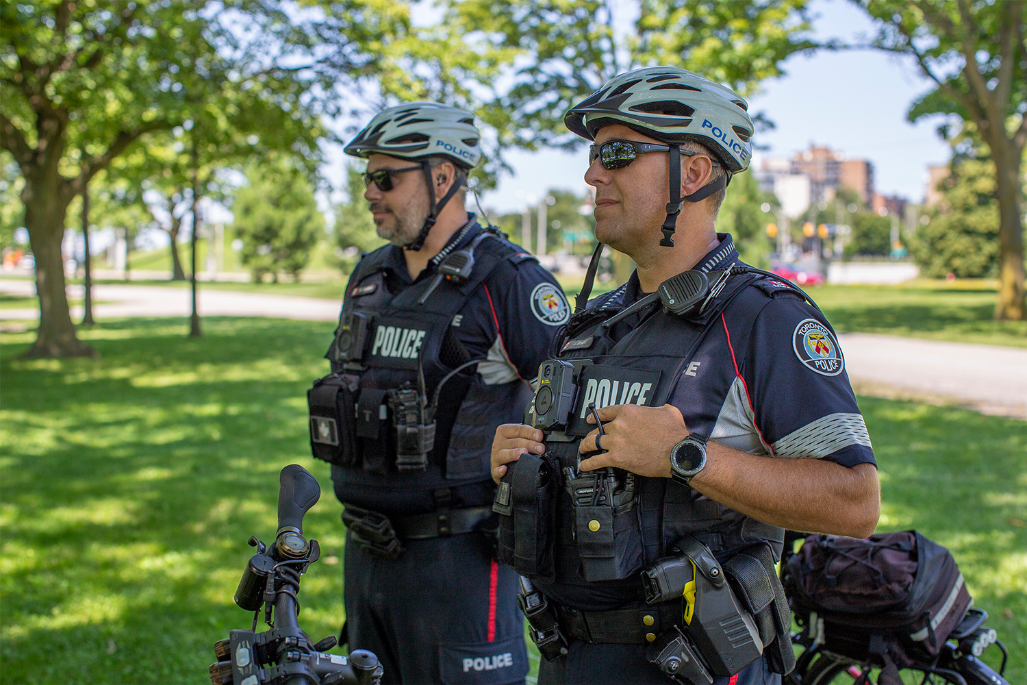 Police officers watch on during eviction negotiations at Marilyn Bell Park on July 26, 2024. 