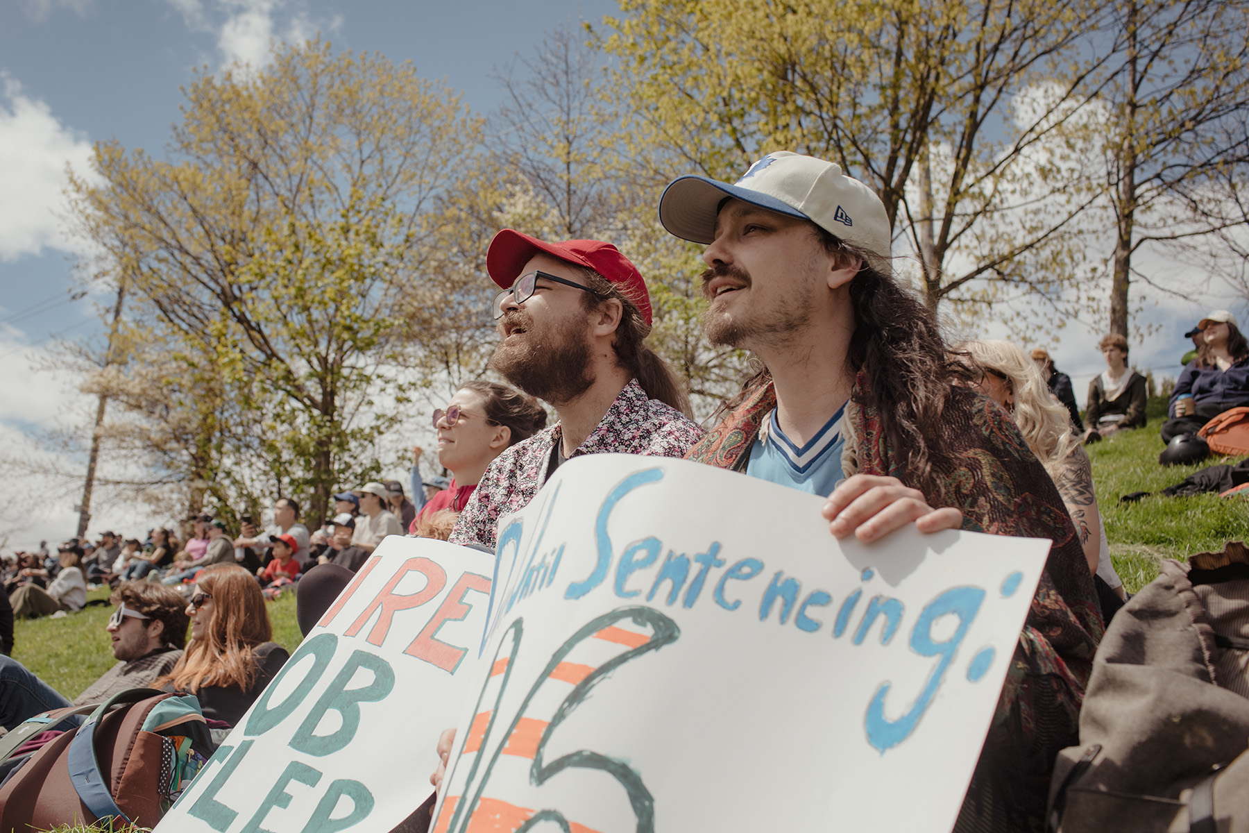 Fans who call themselves “The Bushmen” cheer from the top of the hill at Christie Pitts, close to Christie Street. Right, Daniel Mallett and Aaron Schaefer hold up signs directed at Yasiel Puig.