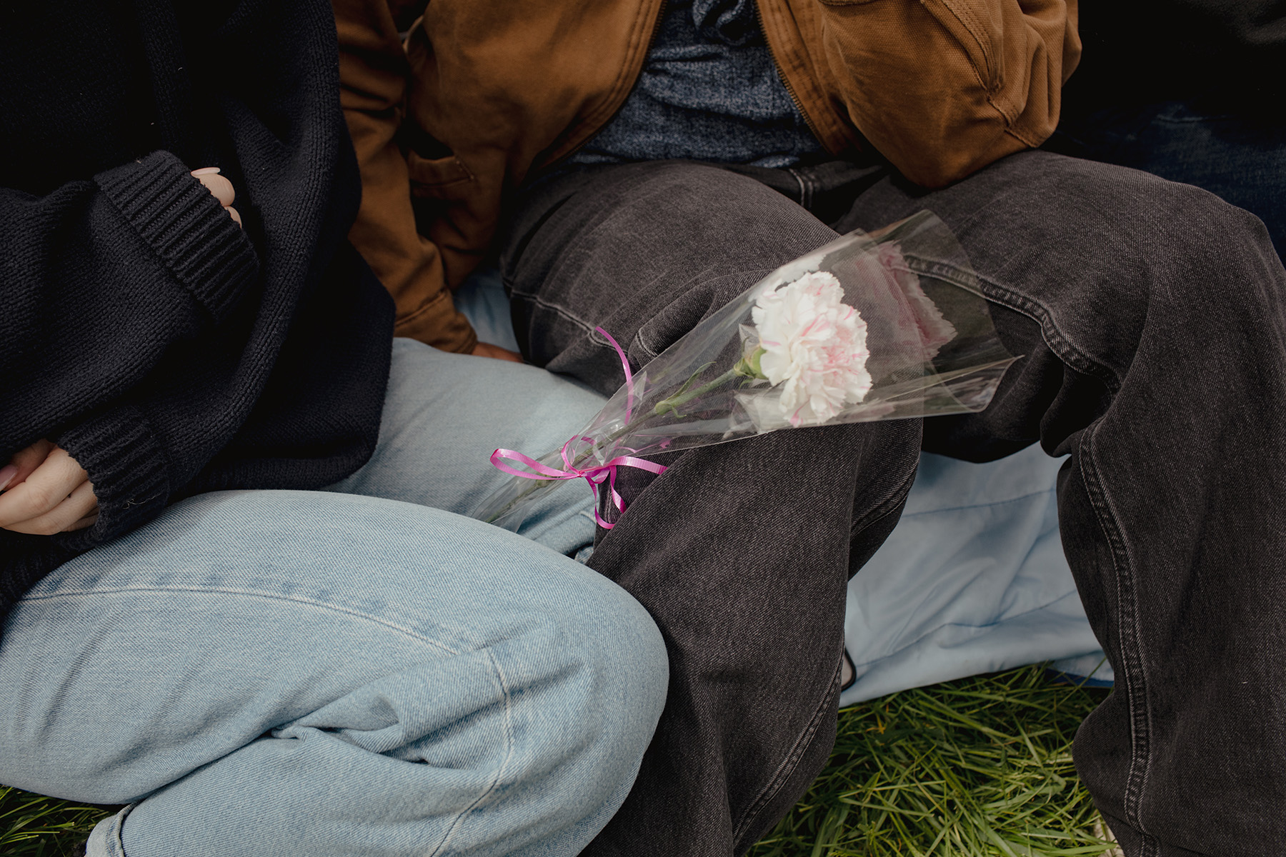 Left, friends gather at a game in Christie Pitts in May. Right, a fan sits with a carnation flower, available at the game on Mother’s Day.