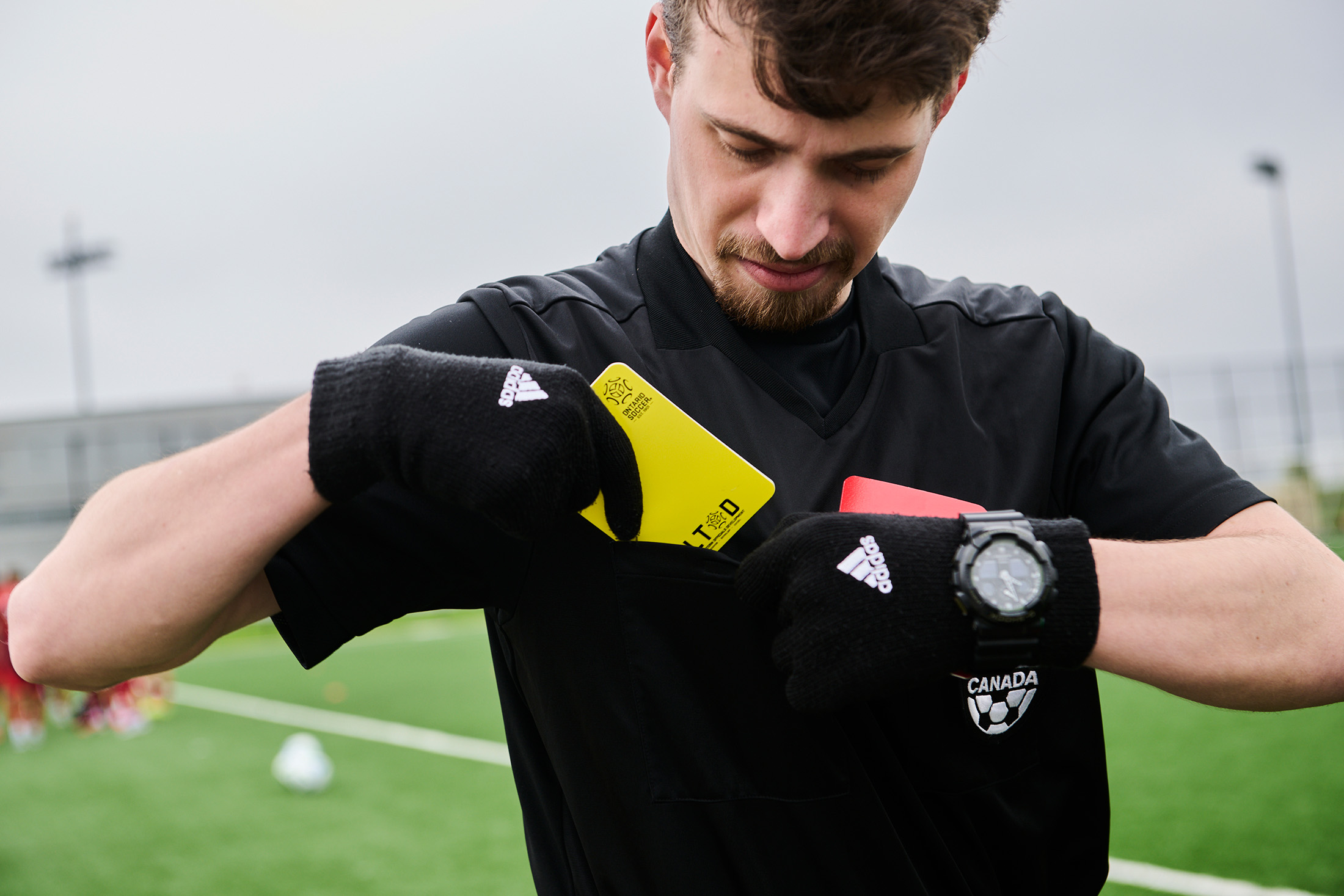 Left, linesman Ben Kivenko checks the yellow cards and other calls in his book after a game. Right, Kivenko prepares to officiate.