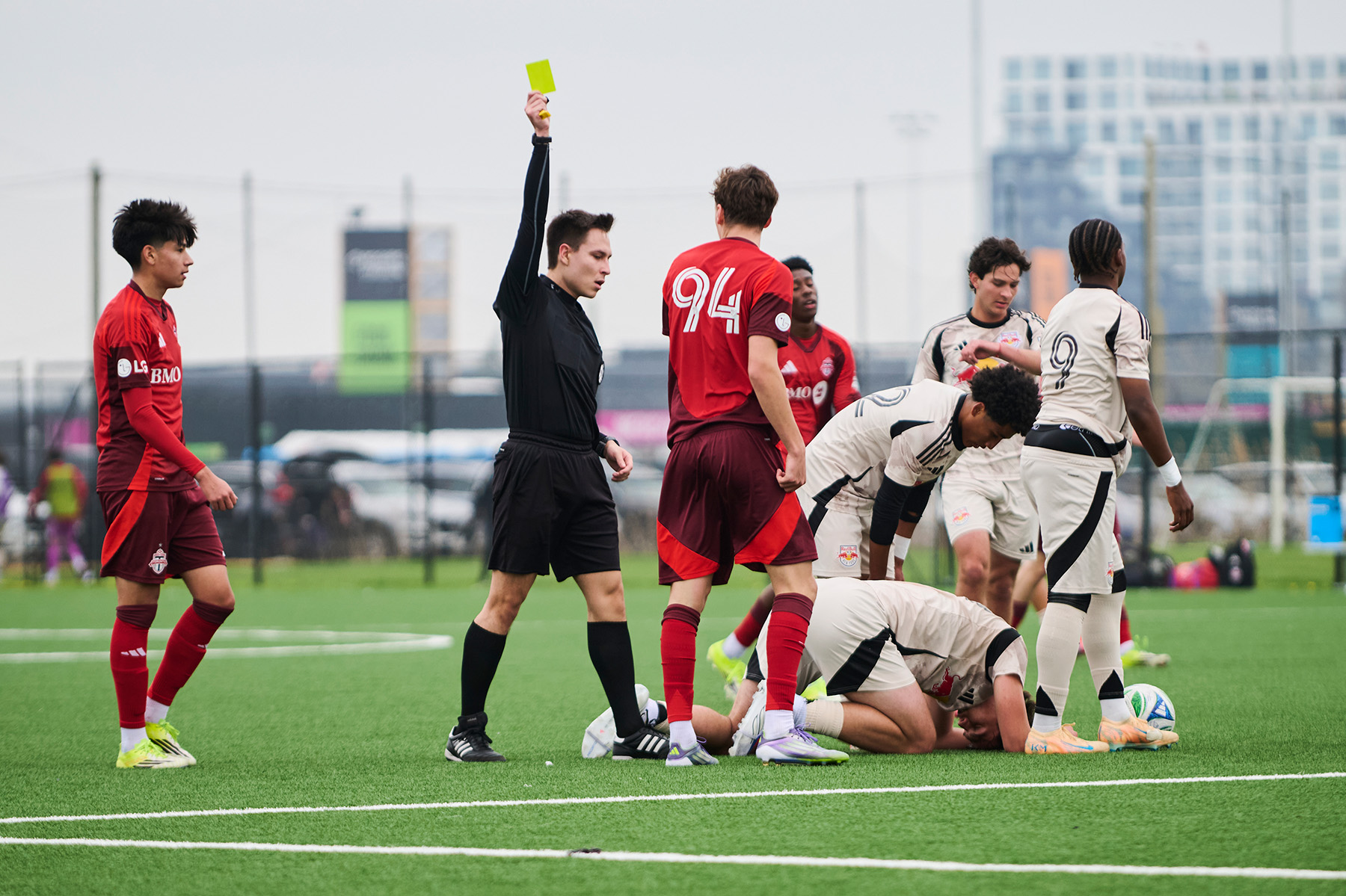 Referee Mariusz Buczkowski issues a yellow card to a Toronto FC player during a game between the Toronto FC and New York Red Bulls academy teams at Downsview Park.