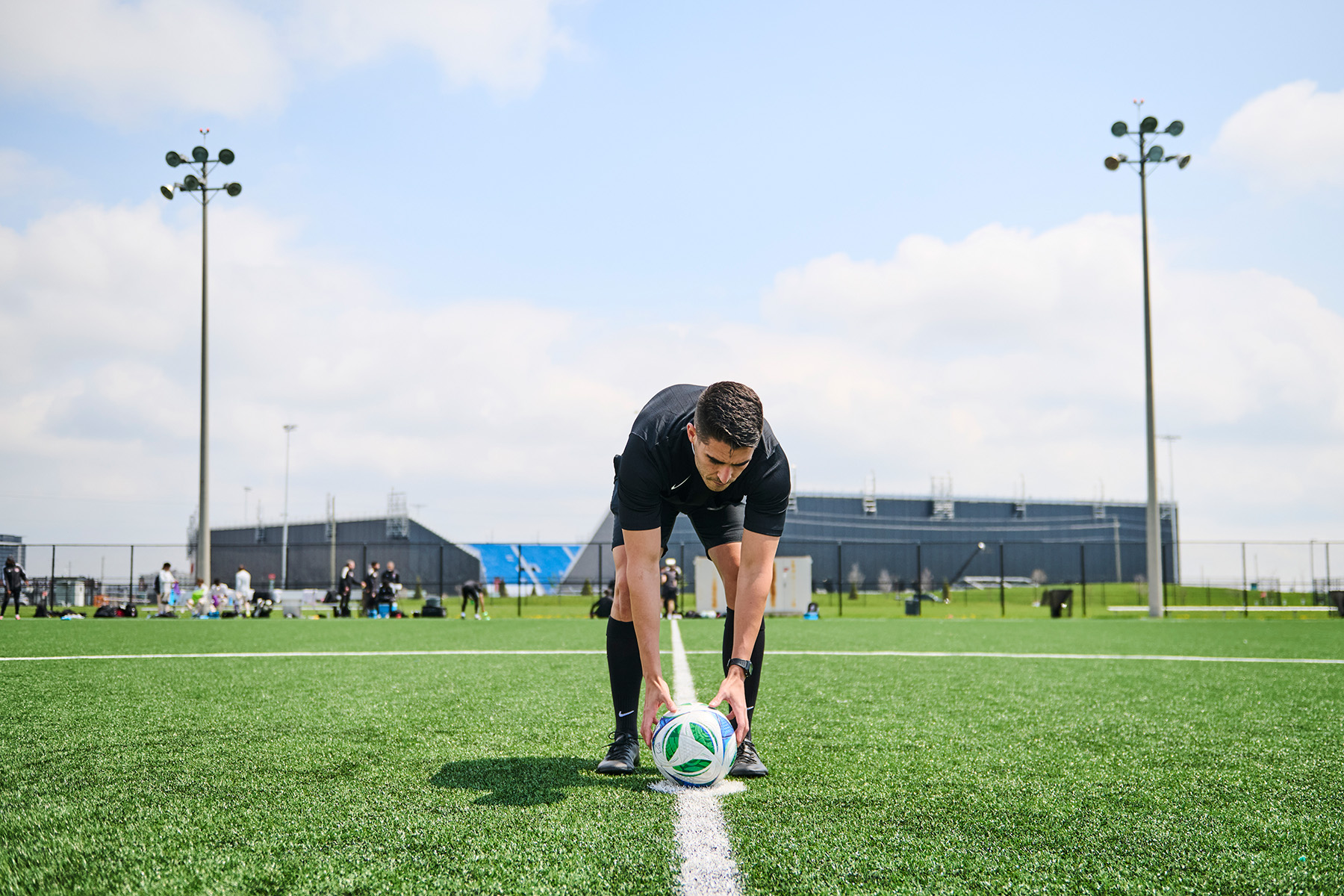 Referee Josue Tomas places the ball on the centre circle at the start of a game.