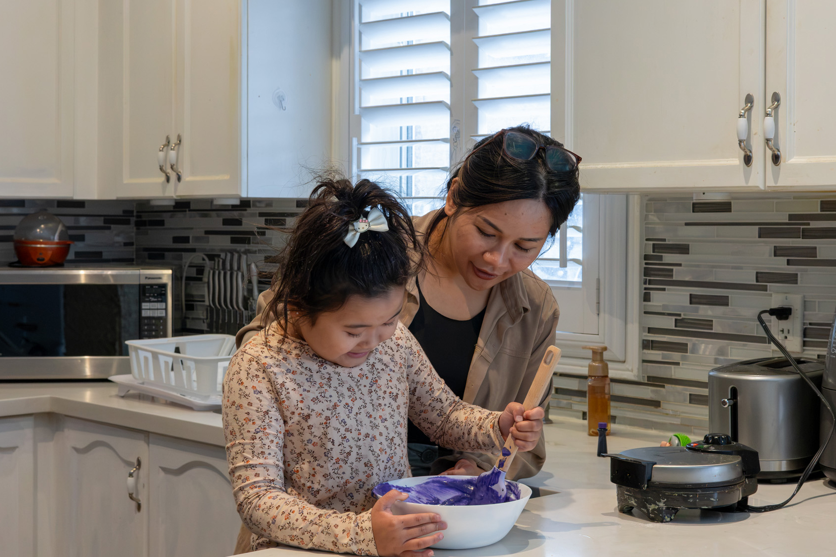 Maria Carillo helps her daughter Katalina make a purple waffle. 