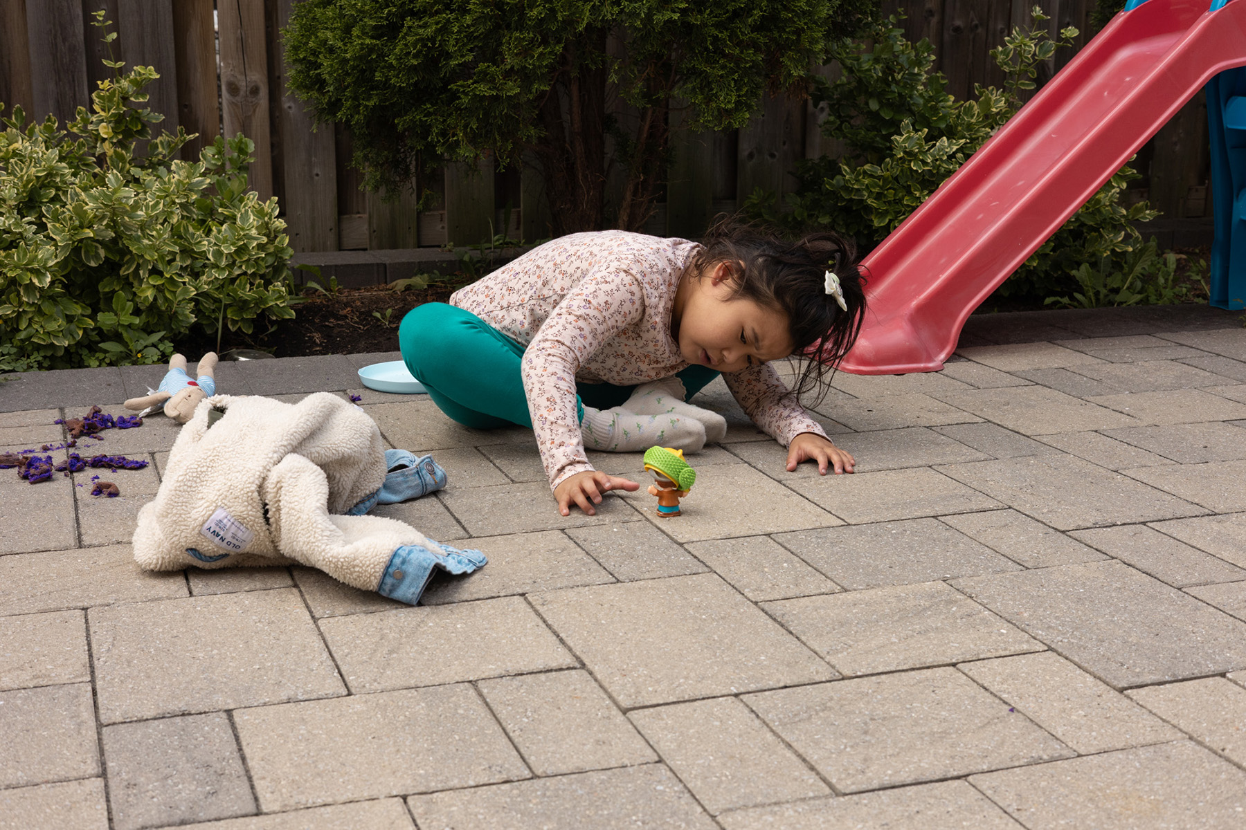 Katalina Carillo plays with her toys in her backyard.