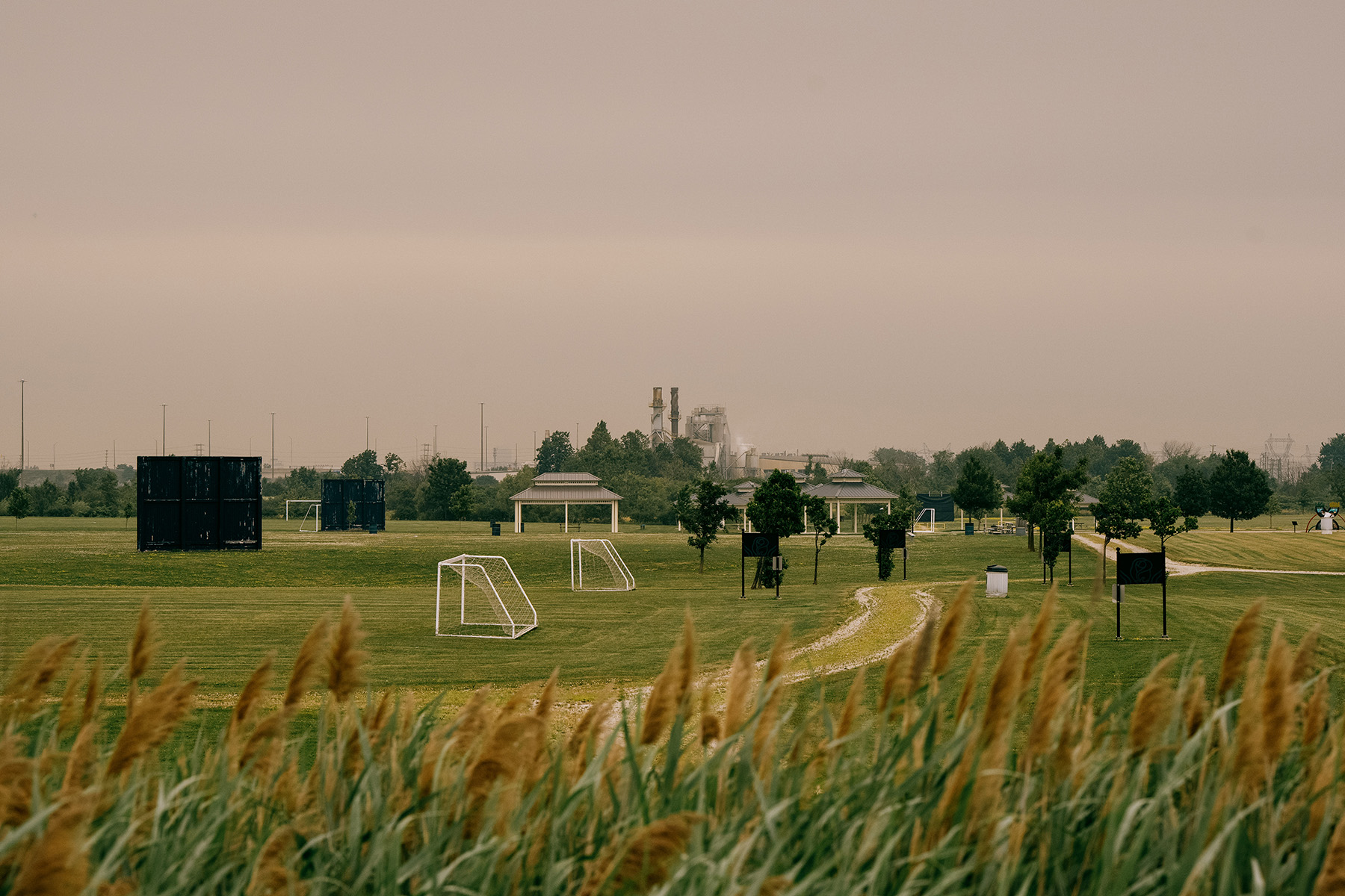 The smokestacks of the Emerald Energy From Waste incinerator are visible from a nearby soccer field.