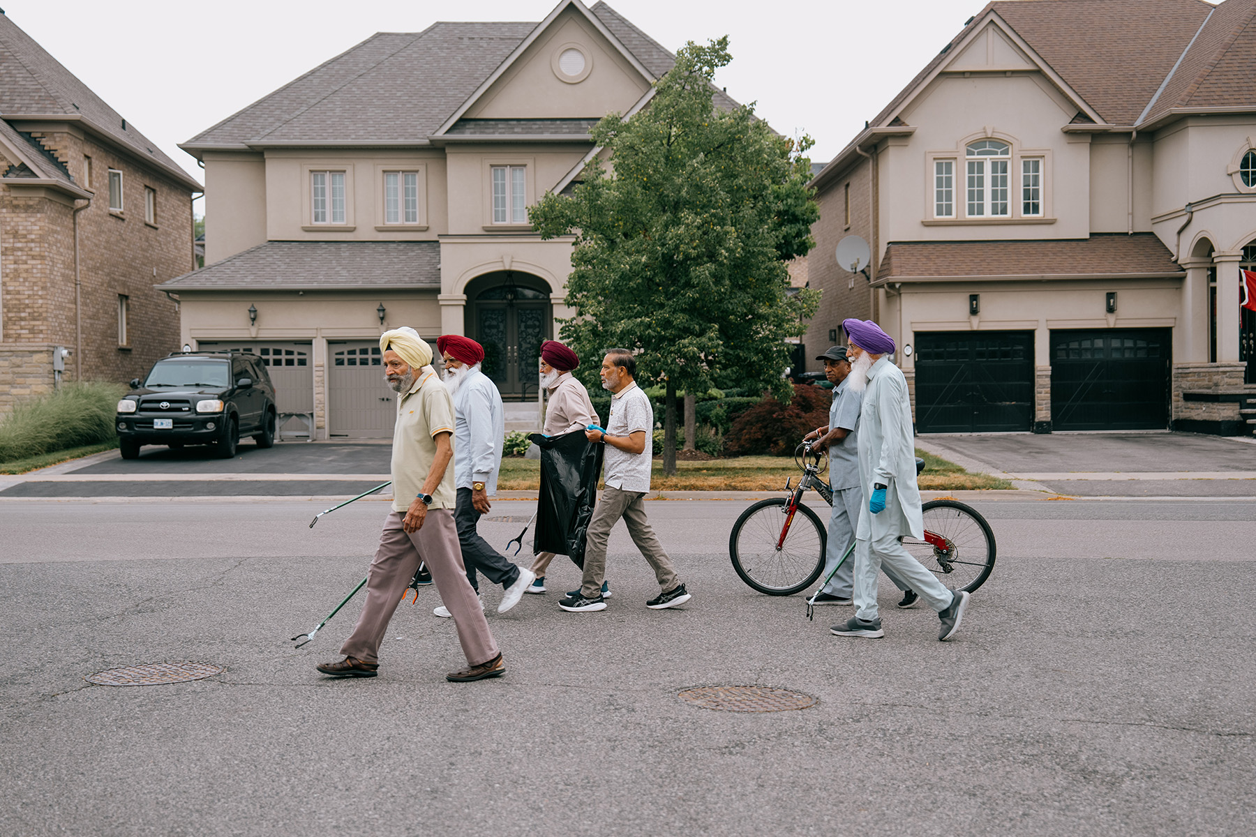 Members of local cleanup crew organized by Rajbalinder Ghatoura walk through the neighbourhood surrounding Luongo Park in Brampton.