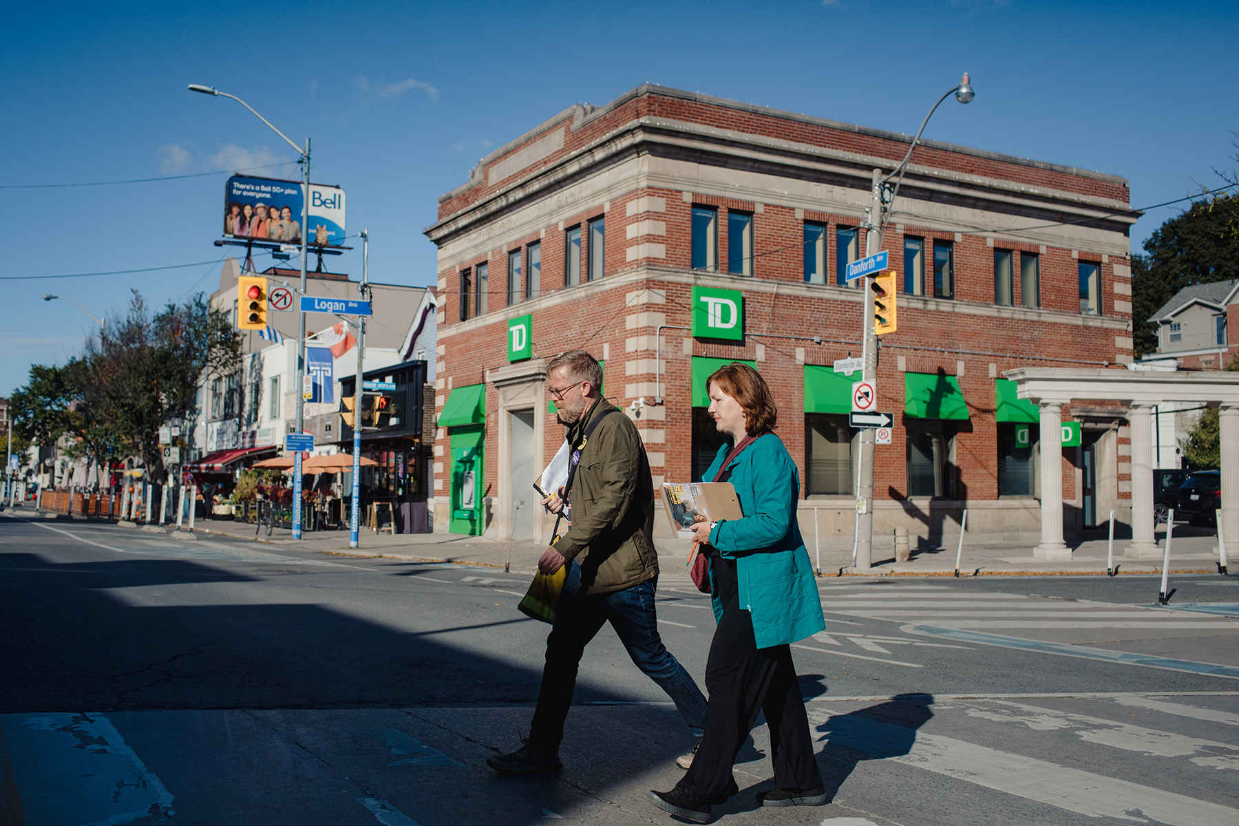 Sara Ehrhardt crosses Danforth Avenue with a volunteer while canvassing. Photo by Chloë Ellingson / The Local