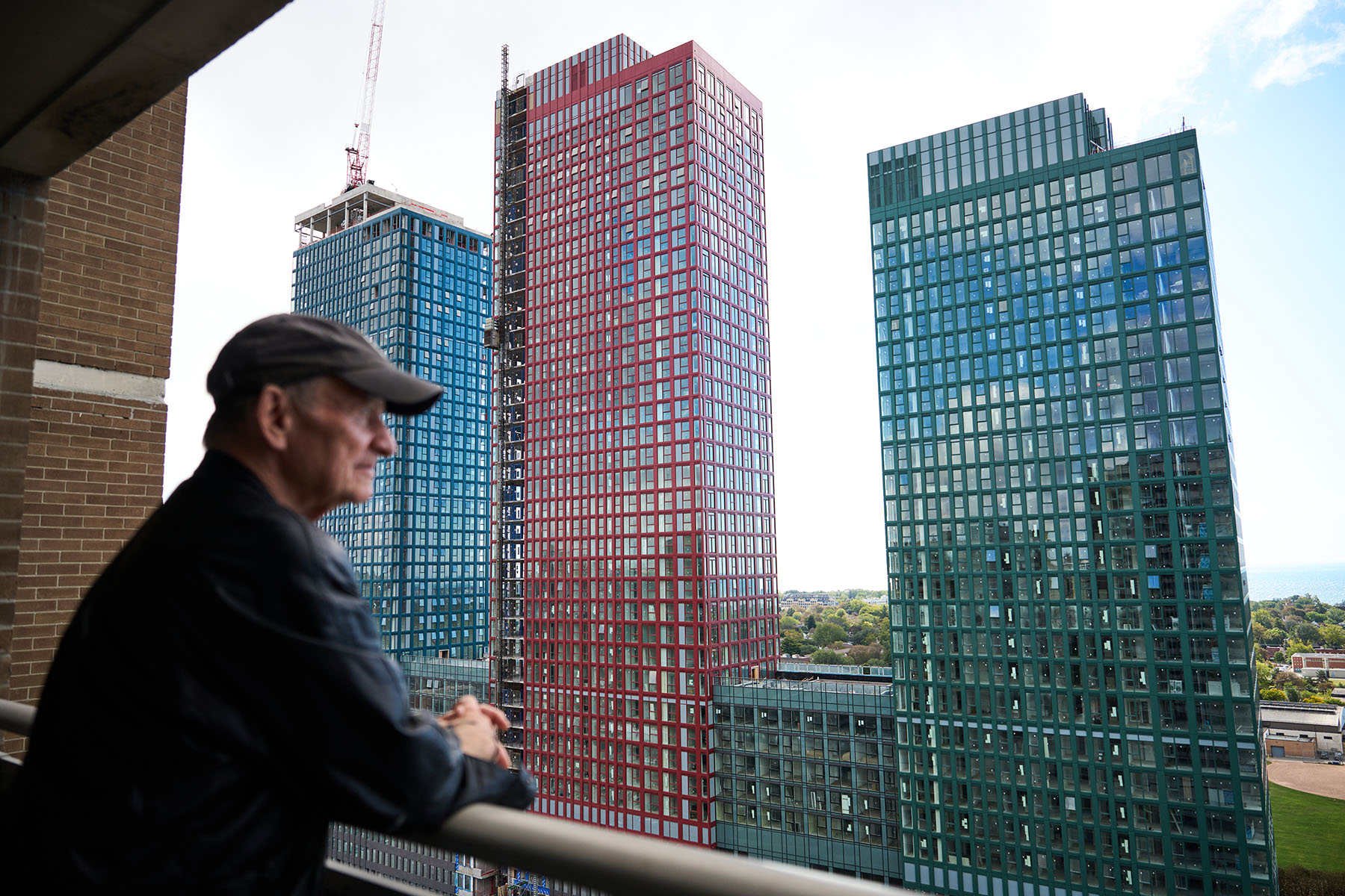 Danforth Village resident Gary Kassbaum looks out from his balcony, his view of the lake now largely obstructed by new buildings.
