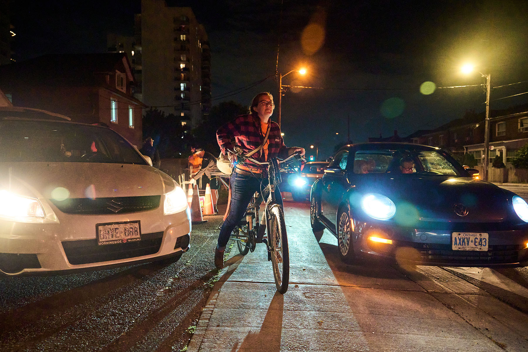 Left, volunteers remove the last Padovani lawn signs from a garage on Eglinton Avenue on the eve of October 1. Right, volunteer Kelsey Carrière sets out to put up lawn signs, which she has attached to her bike.